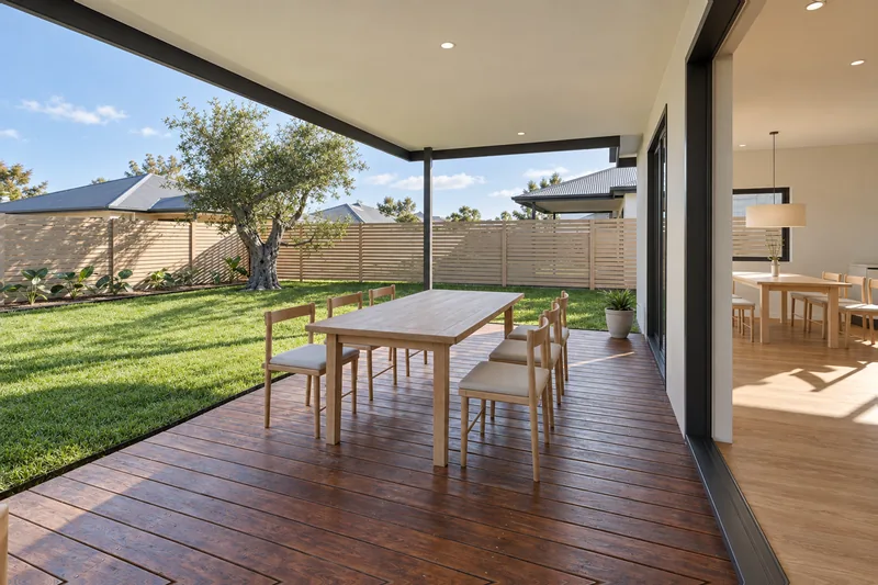 The covered alfresco with an outdoor dining table and the back garden