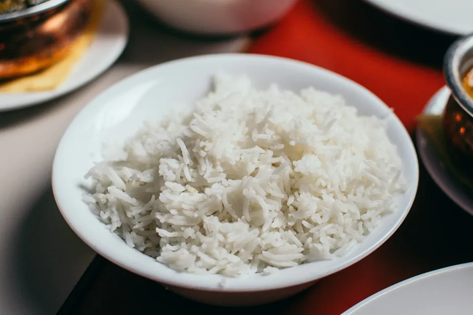 A white bowl of steamed long-grain rice